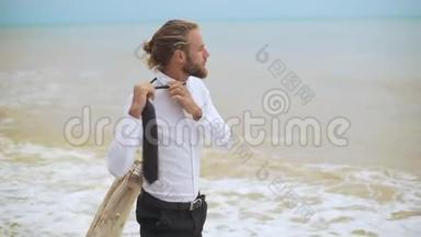 金发的年轻商人松开领带，慢慢地把它扔到海边